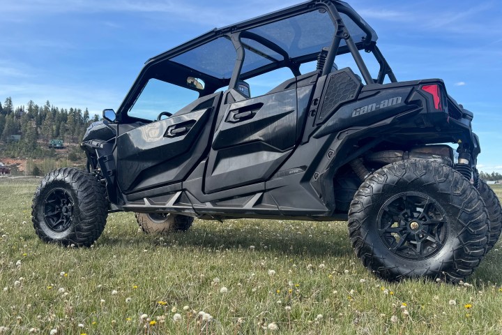 ATV parked on grass with trees and sky in background.