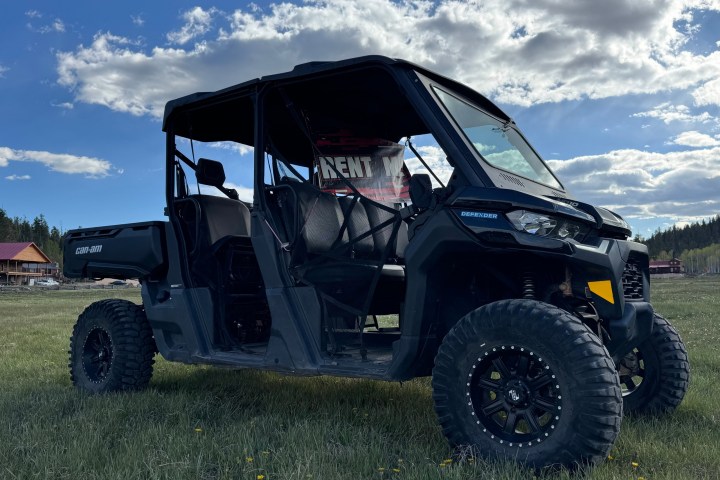 Off-road vehicle parked on grassy field under cloudy sky.